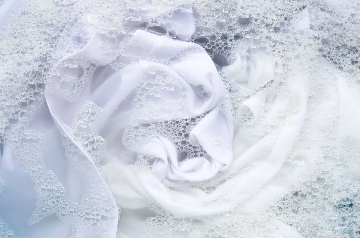 white clothes being washed in cold soapy water