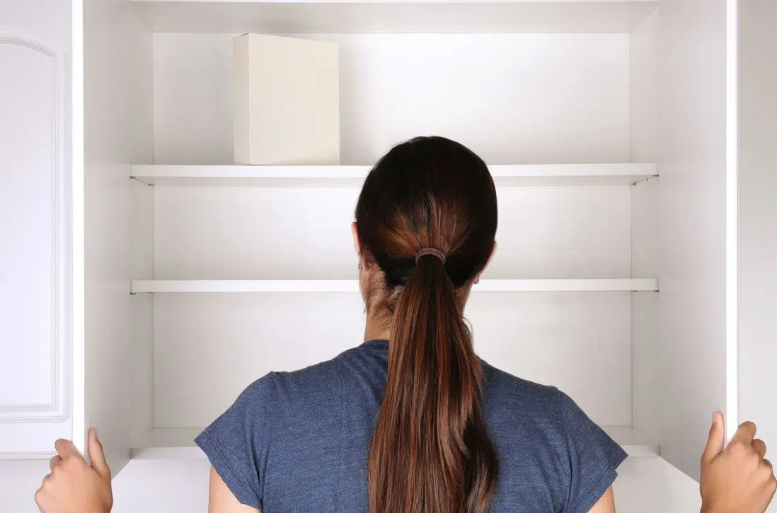 woman look into empty white pantry
