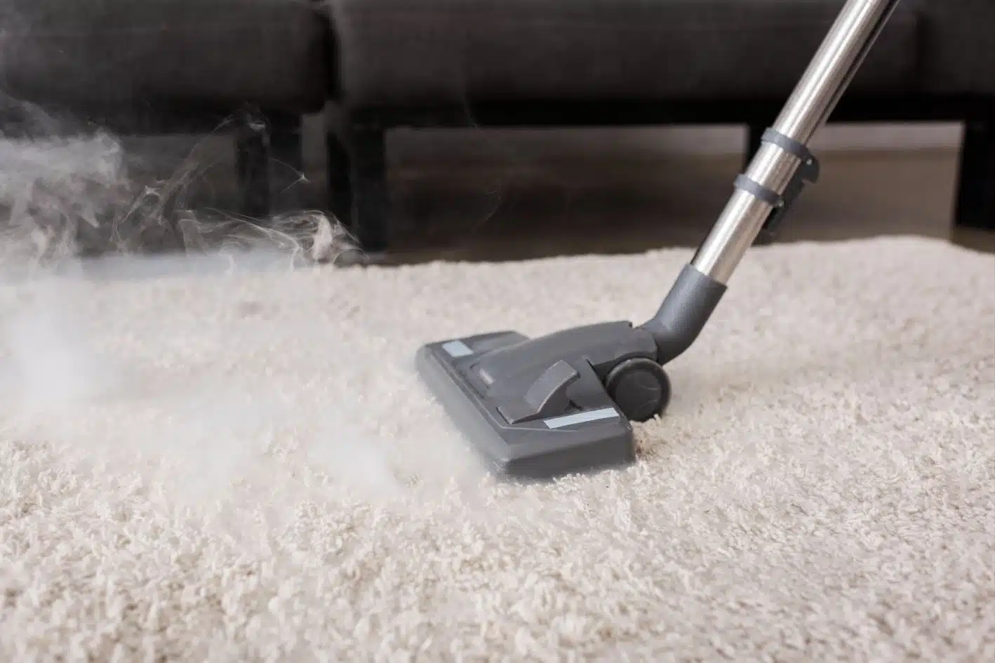 person vacuuming white fluffy carpet