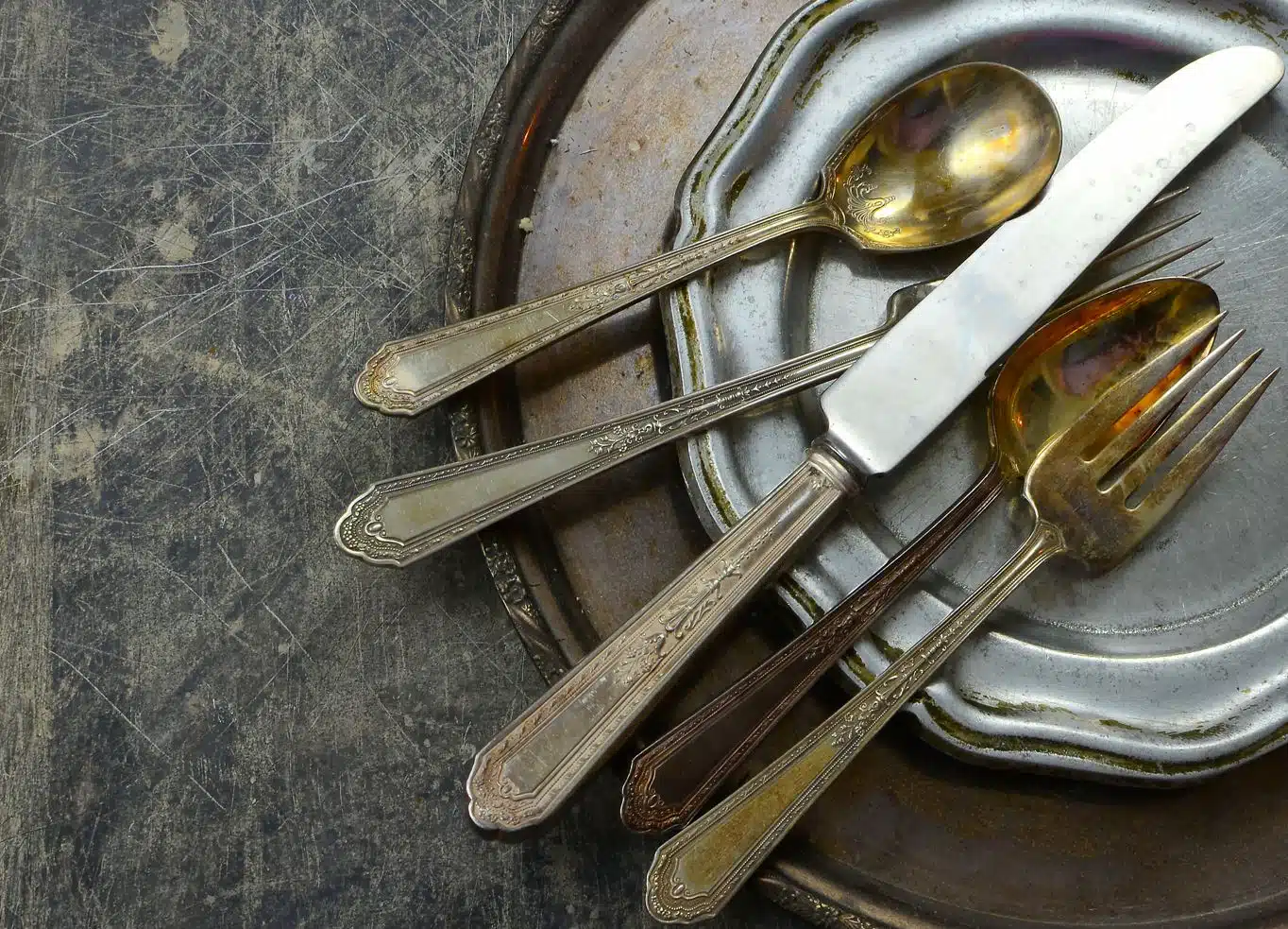 top view of dirty pewter cutlery and plates