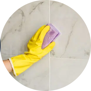 Juan Carlos MaidForYou cleaner scrubbing white tile with yellow gloves
