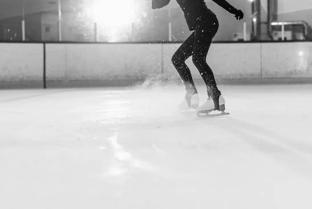 girl figure skating at an indoor ice skating rink