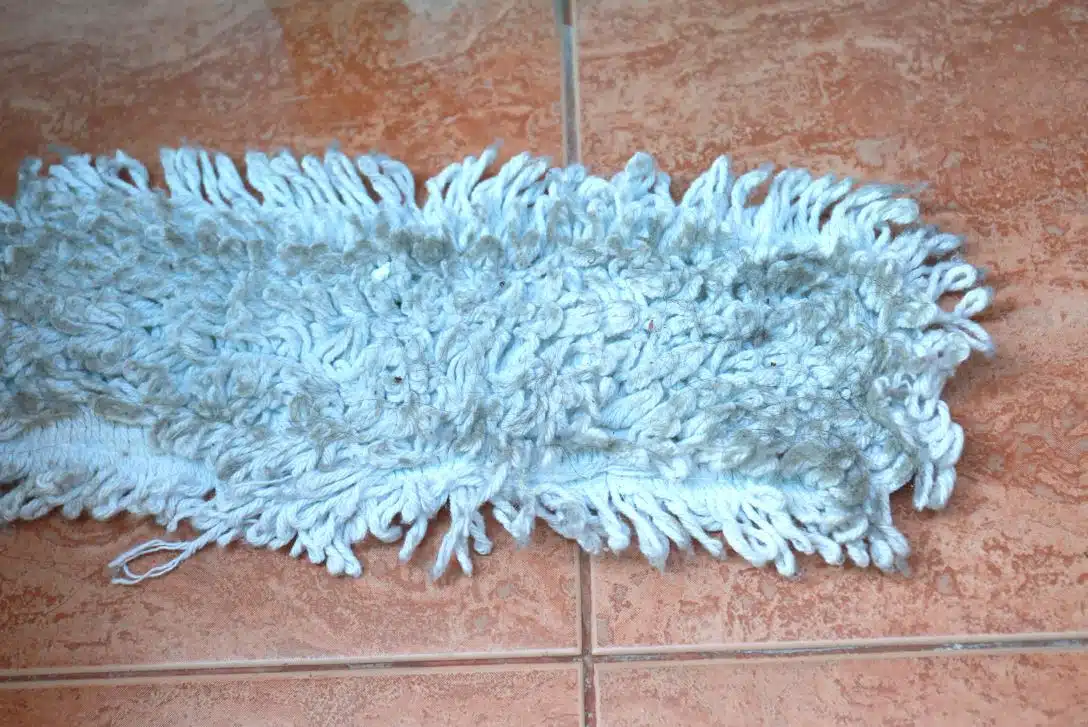 dirty blue steam mop pad on a tiled floor