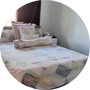 close up of freshly made single bed with pink and grey quilt cover