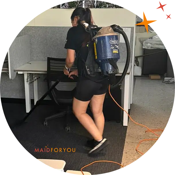 Chuka, a Maidforyou cleaner, tidying beneath office desks.