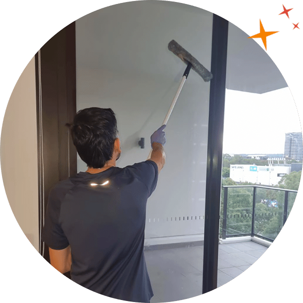 MaidForYou cleaner Jonathan using squeegee to clean balcony window
