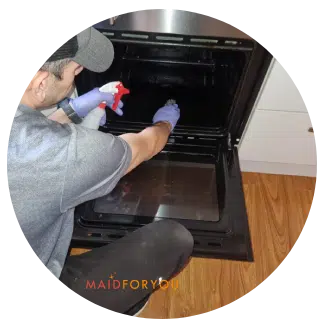Jonathan cleaning the interior of a dirty oven.