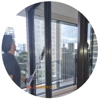 Jonathan using an extended squeegee to clean balcony windows