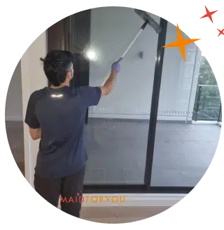 Jonathan using an extended squeegee to clean the internal windows of a balcony.